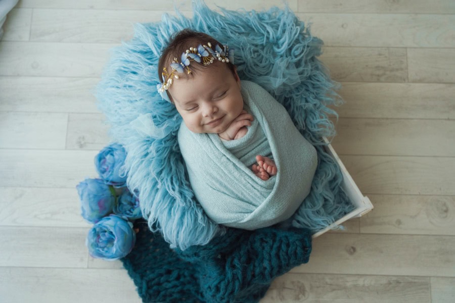 Fotografo newborn Napoli, neonato addormentato in posa avvolto in copertina morbida